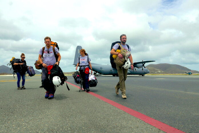 Four veterans carrying gear walk on an airstrip in front of a military aircraft, symbolizing their resettlement journey from service life to Civvy Street.