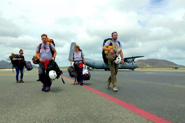 Four veterans carrying gear walk on an airstrip in front of a military aircraft, symbolizing their resettlement journey from service life to Civvy Street.