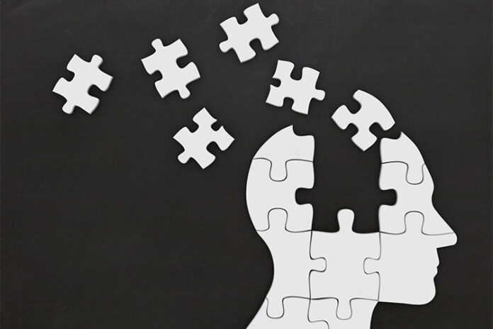 A puzzle forming the silhouette of a human head, reminiscent of a veteran transitioning to Civvy Street, with several pieces floating away against a dark background.