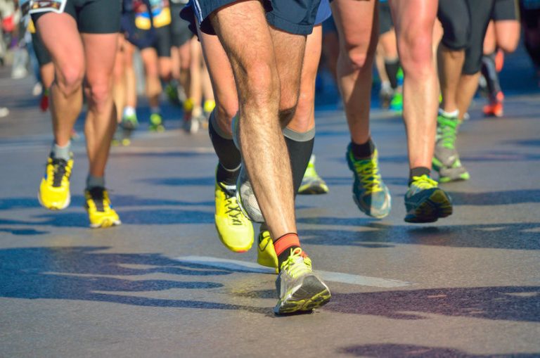 Runners in athletic shoes, including veterans transitioning from Civvy Street, participate in a road race, with the focus on their legs and feet.