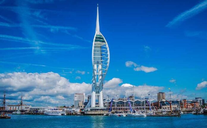Spinnaker Tower in Portsmouth, UK, stands tall against a blue sky with scattered clouds; boats and the harbor bustle below. Nearby, veterans find new adventures on Civvy Street as they embrace resettlement and fresh beginnings.