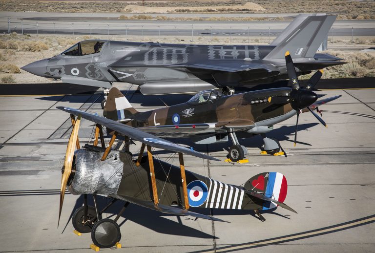 Three fighter planes, a biplane, a World War II-era plane, and a modern jet, are parked in a row on an airfield. Each aircraft symbolizes the evolution of aviation as much as it reflects the journey of veterans transitioning from military service to Civvy Street.