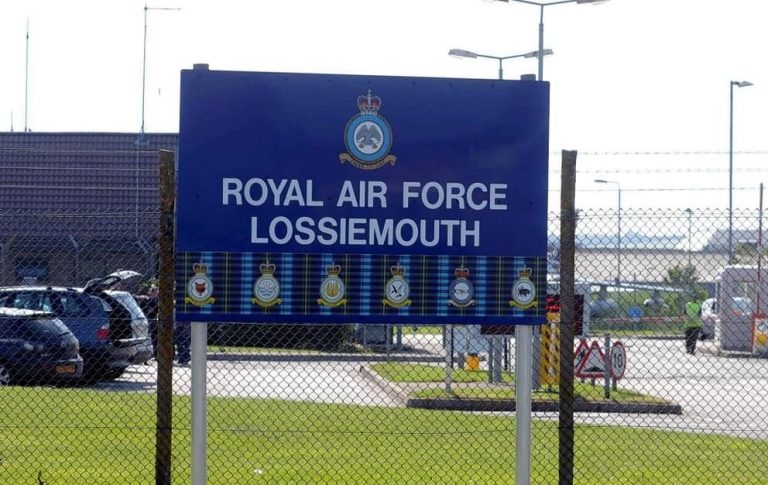Sign for Royal Air Force Lossiemouth behind a chain-link fence, with Pathfinder emblems displayed below the text.
