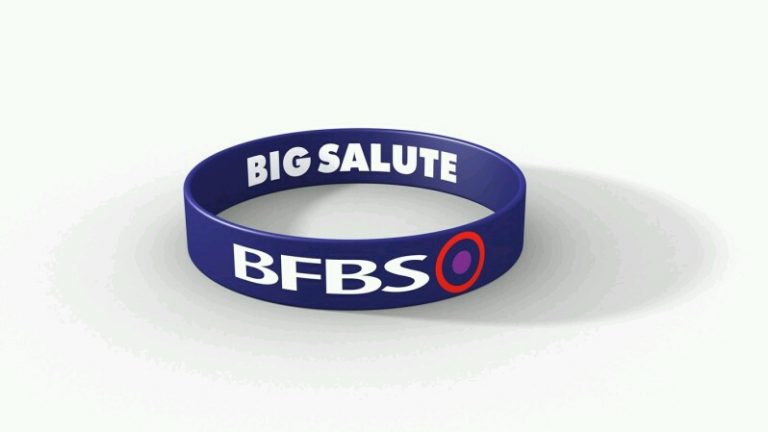 A blue wristband, emblazoned with "BIG SALUTE" and "BFBS" in crisp white letters, honors our veterans and the military community.