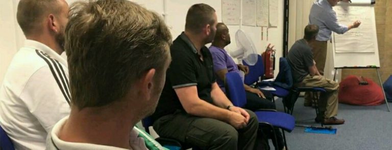 In a classroom filled with attentive pathfinders and resettled veterans, a person stands at the flip chart, guiding them through an insightful session focused on new beginnings and opportunities.