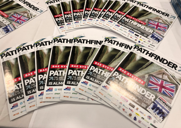Stacks of magazines titled "Pathfinder," featuring a Union Jack flag, BAE Systems logo, and multiple sponsor logos, are neatly arranged on a table, spotlighting Armed Forces initiatives.