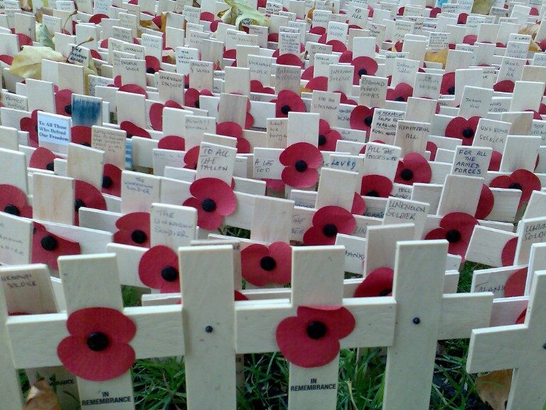 Rows of small wooden crosses with red poppies and remembrance messages are arranged on the grass at Westminster Abbey's Field Of Remembrance.