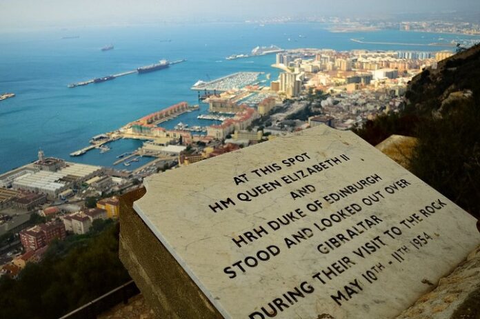 Plaque overlooking a city and harbor in Gibraltar, commemorating the importance of the visit by Queen Elizabeth II and the Duke of Edinburgh on May 10-11, 1954.