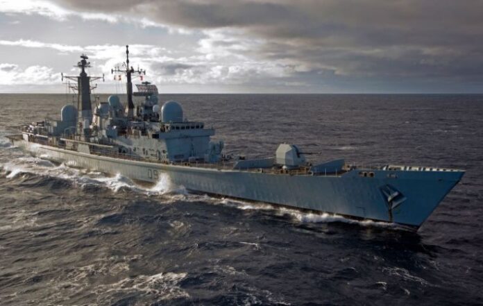 The mighty frigate HMS Edinburgh sails on the ocean under a cloudy sky.