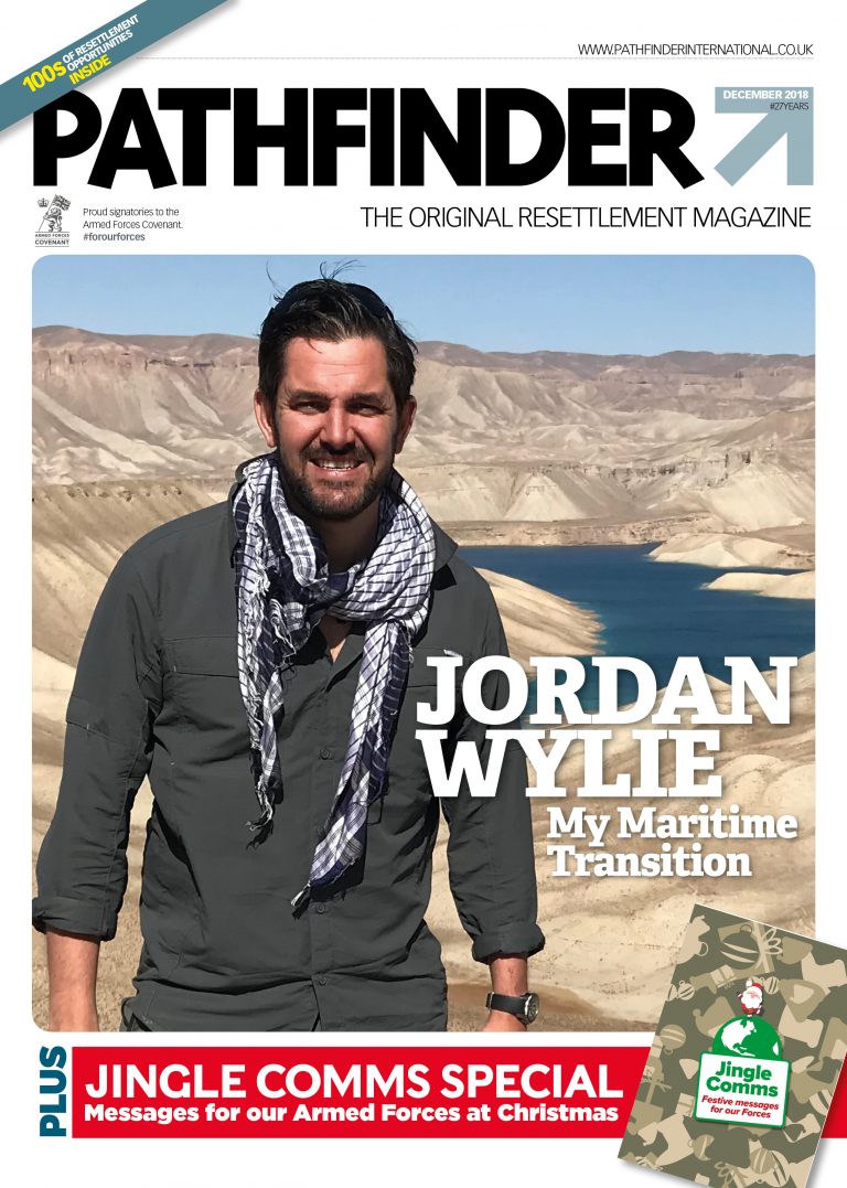 Magazine cover of "Pathfinder International" features a man by the water in a natural landscape, wearing a dark shirt and scarf. Text reads "Jordan Wylie: My Maritime Transition." December Issue promises insight into his journey.