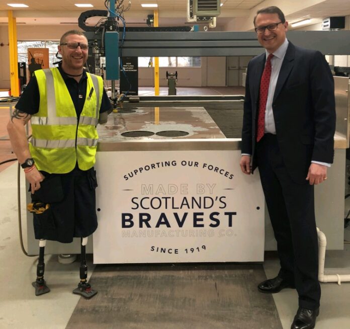 Two men stand next to a machine labeled 