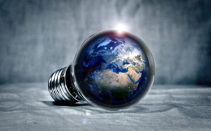 A light bulb with an image of Earth inside it, lying on its side against a textured background, reflects the minister's first green initiative to illuminate military airbases sustainably.