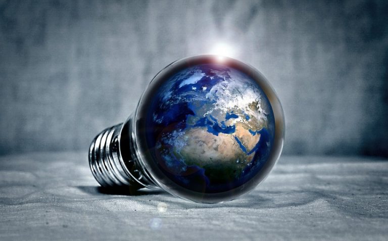 A light bulb with an image of Earth inside it, lying on its side against a textured background, reflects the minister's first green initiative to illuminate military airbases sustainably.