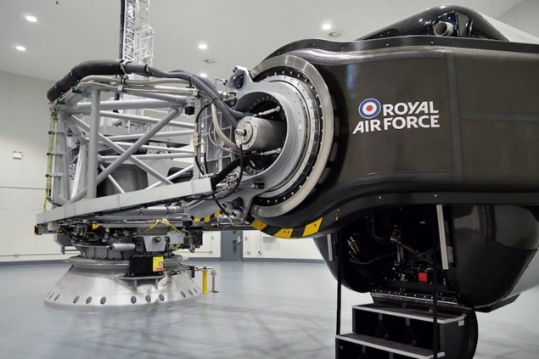 A black flight simulator labeled "Royal Air Force" stands in a spacious room, offering an immersive experience for fast jet training.