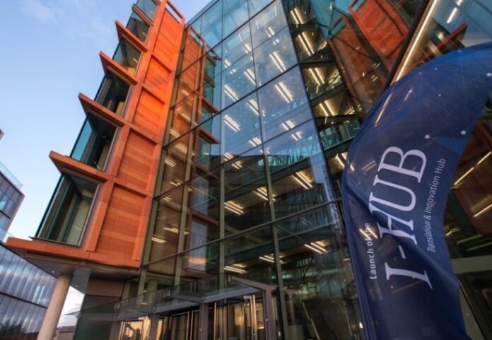 A modern glass building with a blue banner reading 