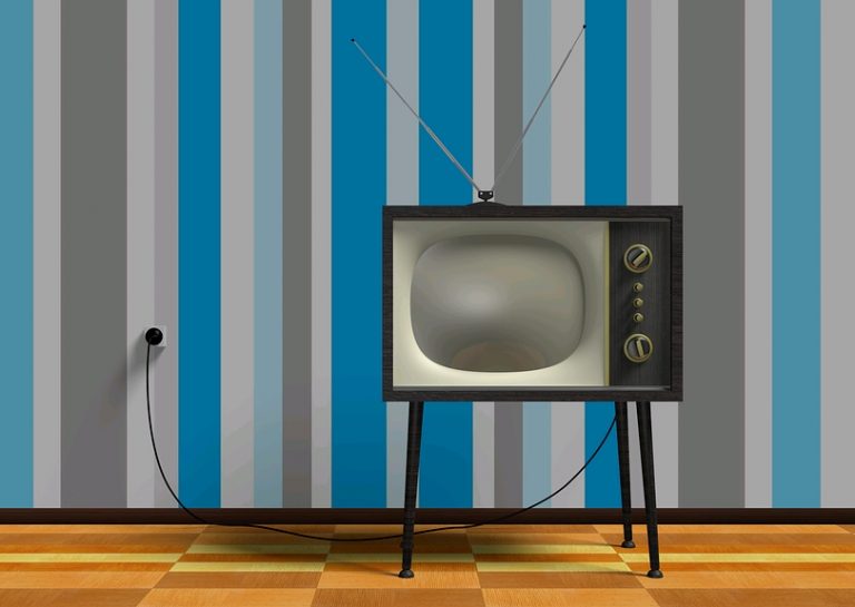 A vintage television with antennas and dials stands on a wooden floor, reminiscent of bygone TV careers. The wall behind features vertical stripes in shades of blue and gray, evoking a sense of nostalgia.
