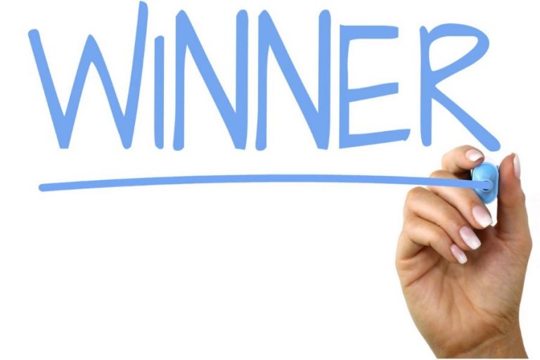 A hand holding a blue marker writes the word "WINNER" in large letters, underlining it with pride, as if announcing a lottery result that benefits veterans' charities.