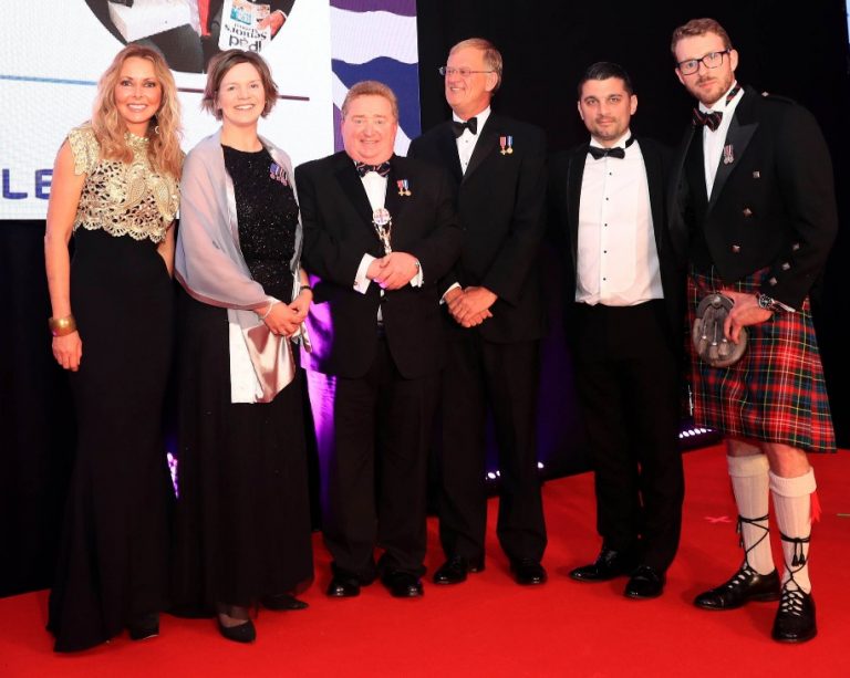 On the red carpet, six people exude elegance in formal attire, with two men proudly wearing kilts. Their gathering celebrates the prestigious Forces Community Award, highlighting the impactful achievements of Project Semaphore.