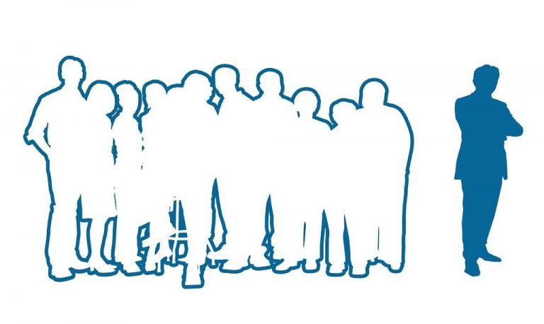 Silhouettes of one person standing apart from a group subtly portray social isolation.