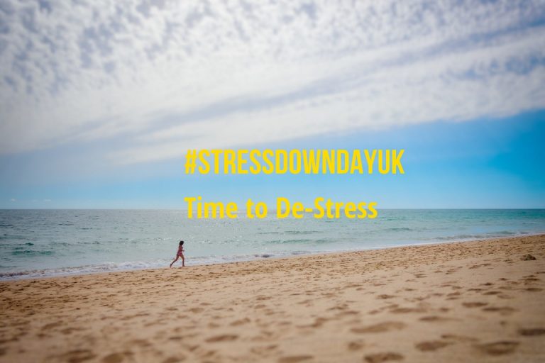 A person walks alone on a sandy beach under a partly cloudy sky, with the words "#STRESSDOWNDAYUK Time to De-Stress" overlaid in yellow text—perfect for those in the Army or military resettlement seeking moments of peace.