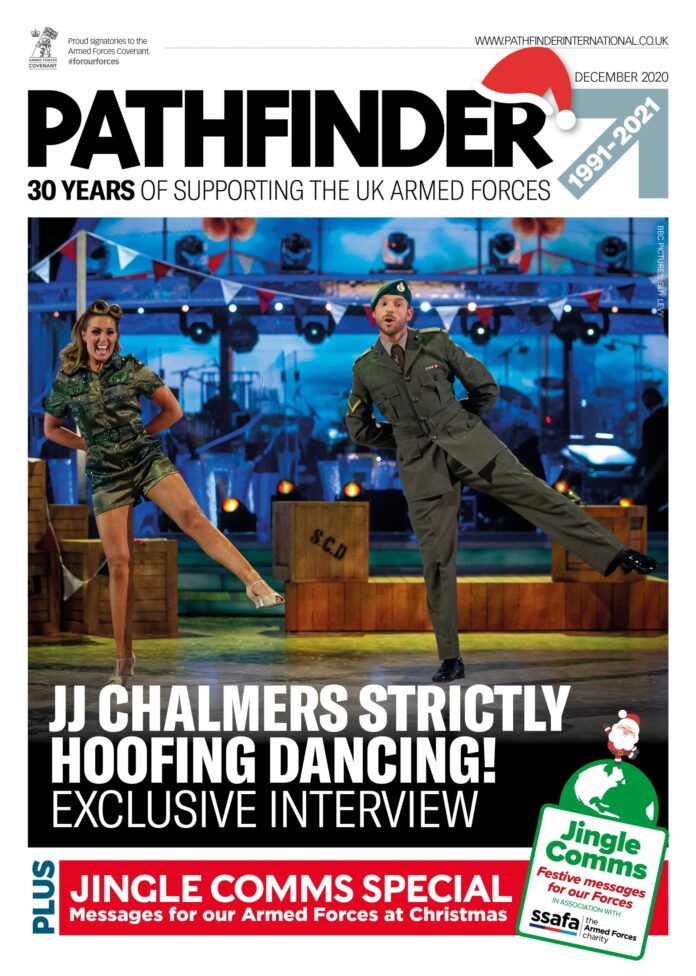 Two performers, one in Army uniform and one in a 1940s-style costume, dance energetically on stage under colorful lights, featured on the cover of Pathfinder magazine.