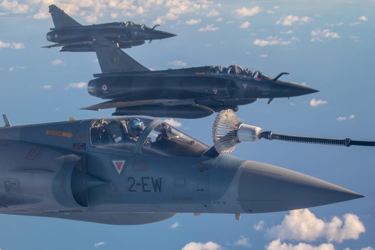 Three military fighter jets in flight, with the nearest jet refueling mid-air using a probe and drogue system—an impressive display of Royal Navy pathfinder precision against a backdrop of clouds and blue sky.