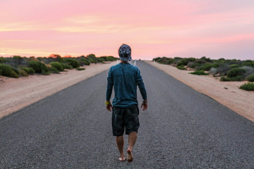 man walking on gray concrete road