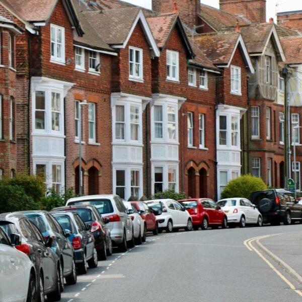 Photo of Vehicles on Road Near Houses