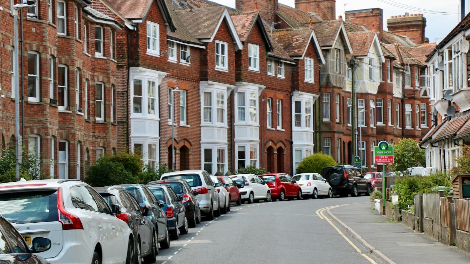 Photo of Vehicles on Road Near Houses