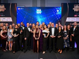 A group of BFA Members in formal attire pose with awards on a stage adorned with banners for the Elite Franchise Awards, celebrating industry excellence at a 2023 event.