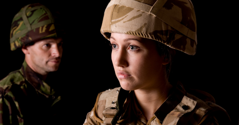 Two soldiers in camouflage uniforms and helmets, one in the foreground and one slightly blurred in the background, stand as symbols of fundamental changes within UK Defence support, against a dark backdrop.