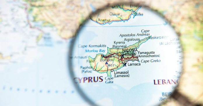 A map of Cyprus is magnified by a glass, highlighting cities like Nicosia, Larnaca, and Limassol—providing context for support for military families and families serving overseas in the Mediterranean region.