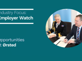 Two men in business attire, one in a military uniform, sit at a table signing documents with "Employer Watch" and "Opportunities at Ørsted" displayed beside them.