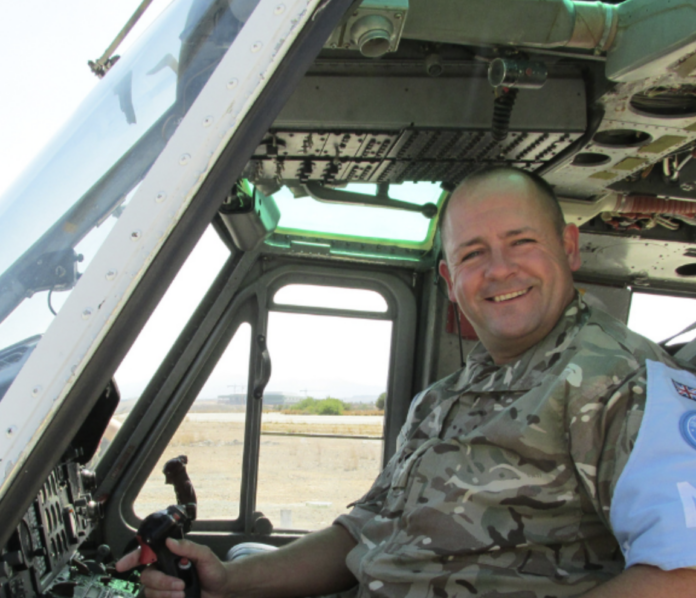 A person in camouflage military uniform sits in the cockpit of a helicopter, smiling at the camera—perhaps embracing a second career and finding purpose beyond probation.